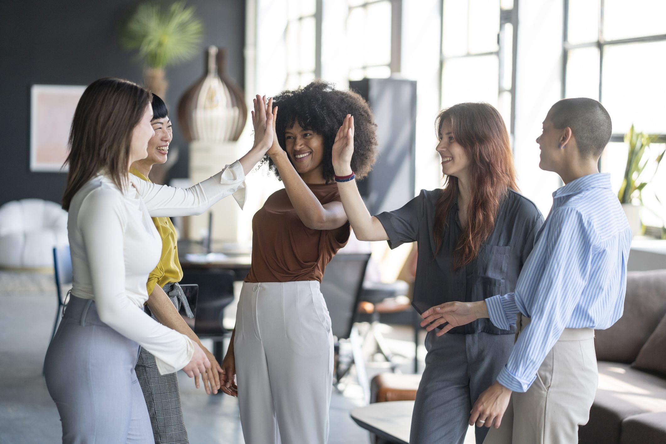 Diverse team high-fiving in modern office
