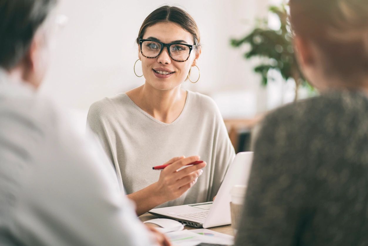 Woman consultant speaking to clients at meeting