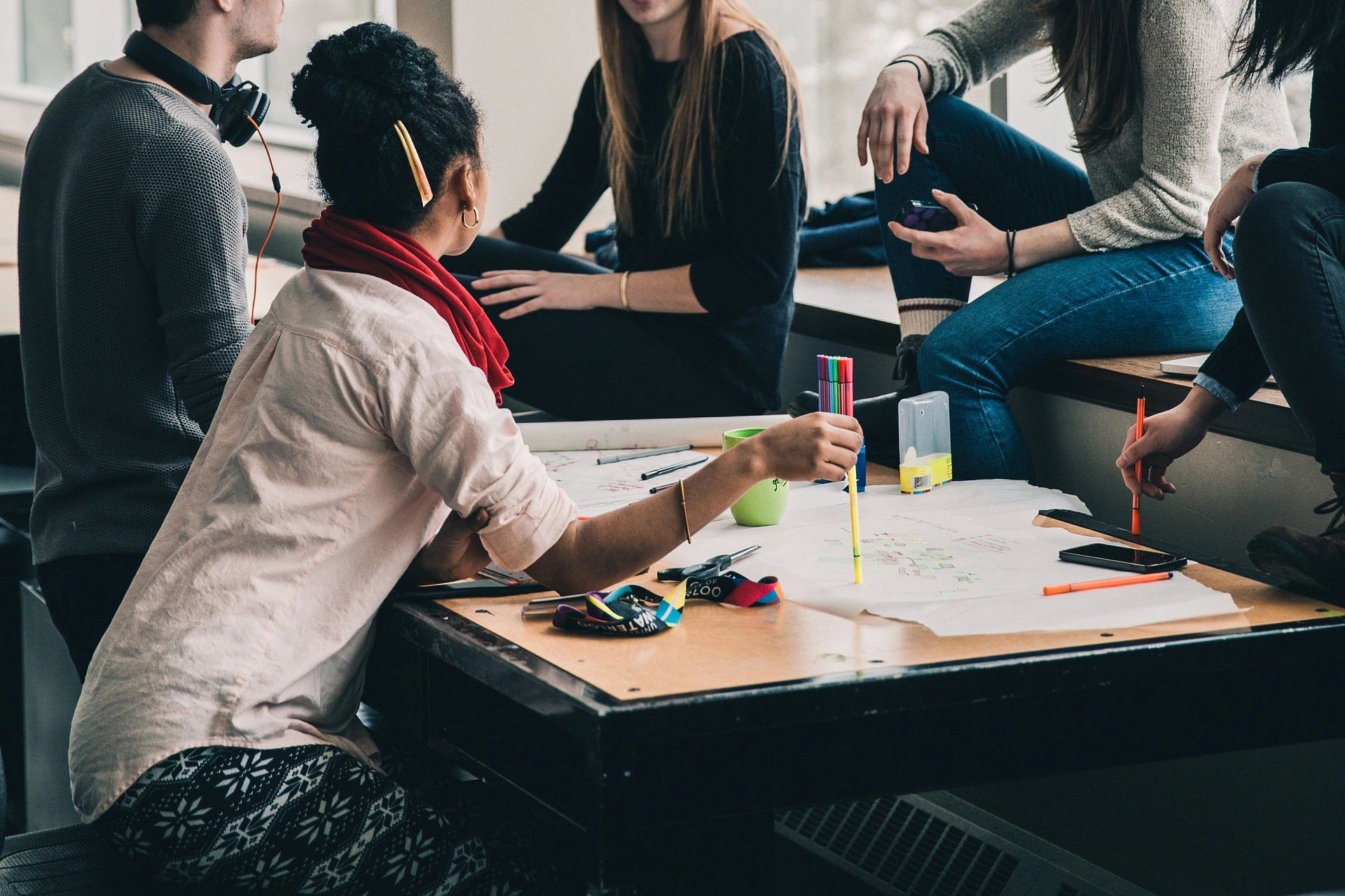 Young adults brainstorming around table with papers