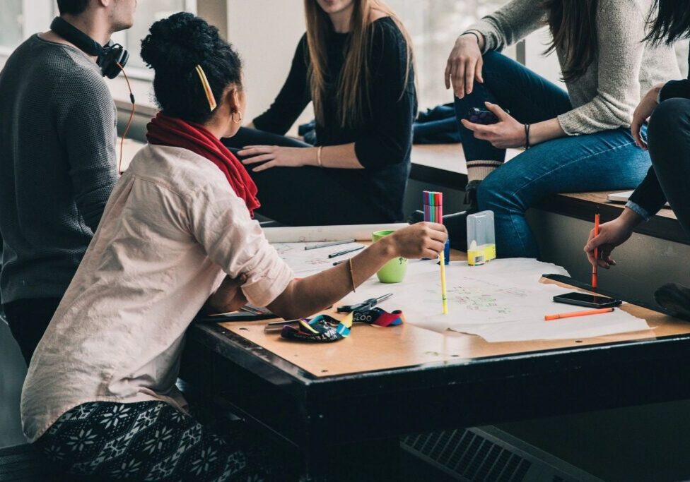 Young adults brainstorming around table with papers