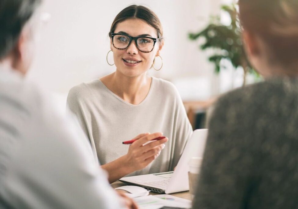 Woman consultant speaking to clients at meeting